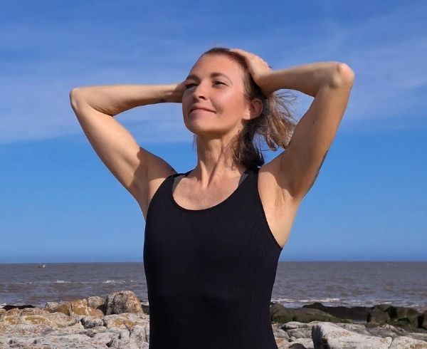 Woman outdoors with relaxed posture and calm expression, representing physical comfort and natural balance in body wellness.